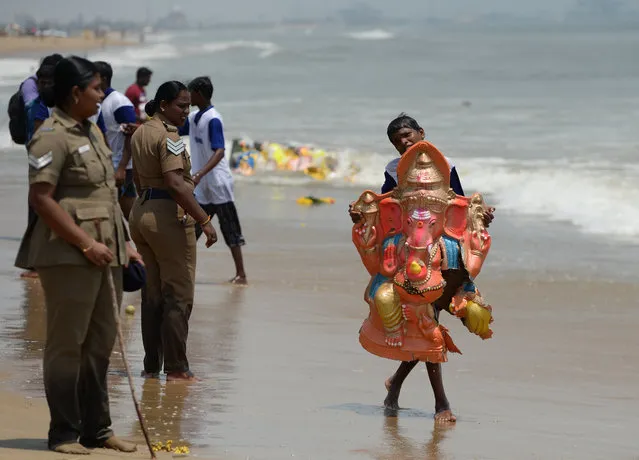 Indian devotees carry an idol of the elephant-headed Hindu god Ganesh for immersion in the Indian ocean at Pattinapakkam beach in Chennai on September 16, 2018, as part of Ganesh Chaturthi festival. (Photo by Arun Sankar/AFP Photo)