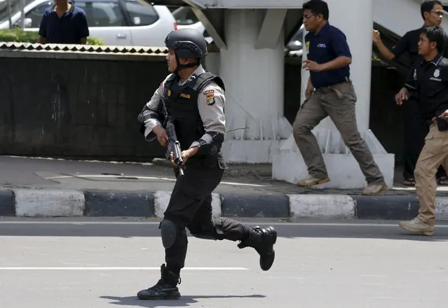 An Indonesian policeman runs near the site of a blast in Jakarta, Indonesia, January 14, 2016. (Photo by Reuters/Beawiharta)