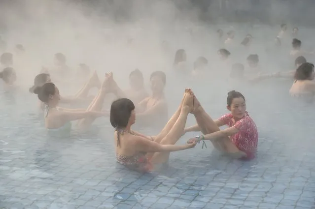 Women practise yoga at a hot spring in Luoyang, Henan Province, China, January 17, 2016. About one hundred attenders performed a Yoga show in minus four degrees Celsius (24.8 degrees Fahrenheit) at a local hot spring yoga culture festival. (Photo by Reuters/Stringer)