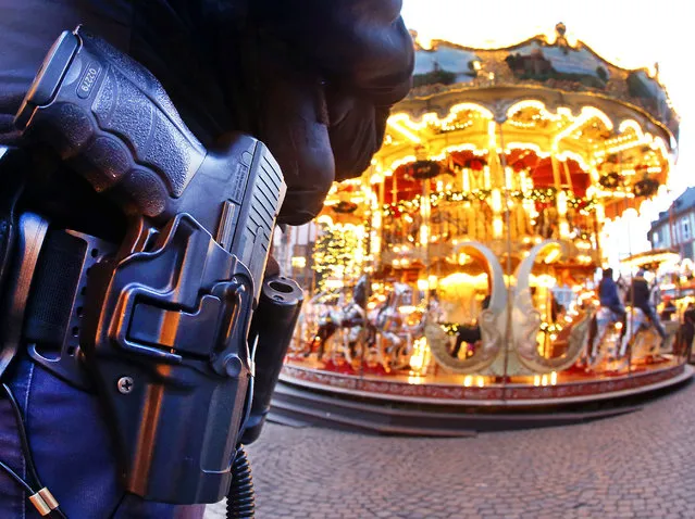A German police officer stands next to a merry-go-round in the Christmas market in Frankfurt, Germany, Tuesday, December 20, 2016 one day after a truck ran into a crowded Christmas market in Berlin killing several people. (Photo by Michael Probst/AP Photo)