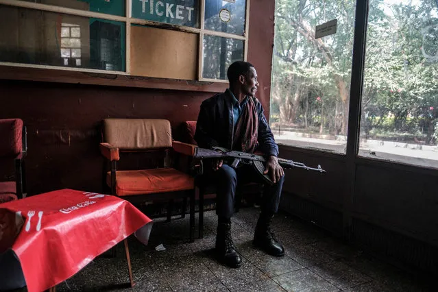 A member of the Amhara police seats with his gun at a distribution center in the city of Bahir Dar, Ethiopia, on June 20, 2021. (Photo by Eduardo Soteras/AFP Photo)