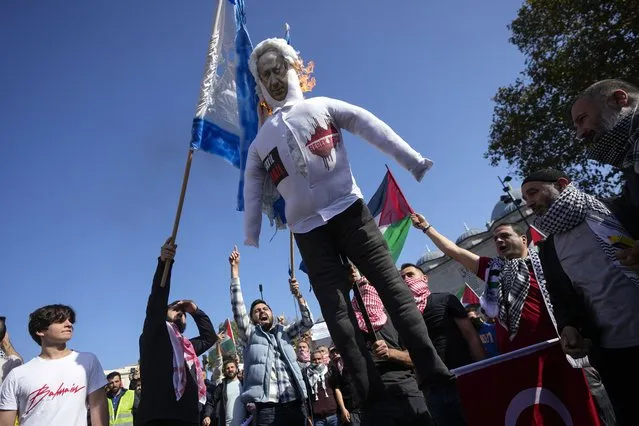 Protesters chant slogans while burning a doll with a picture of Israeli Prime Minister Benjamin Netanyahu, and a mock of an Israeli flag during a protest to show their solidarity with the Palestinians, in Istanbul, Turkey. Friday, October 20, 2023. (Photo by Khalil Hamra/AP Photo)