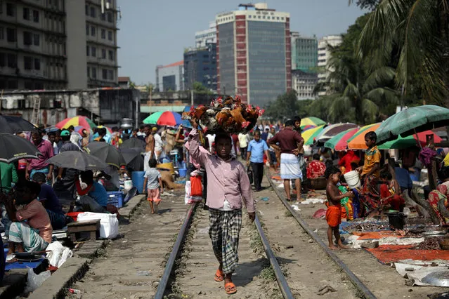 A chicken seller walks along the railway track in Dhaka, Bangladesh, September 17, 2018. (Photo by Mohammad Ponir Hossain/Reuters)