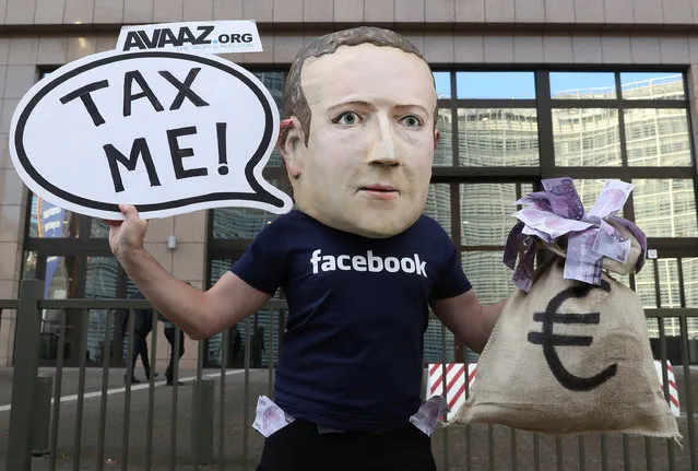 An activist wearing a mask depicting Facebook's CEO Mark Zuckerberg demonstrates during the European Union finance ministers meeting, outside the EU headquarters in Brussels, Belgium, December 4, 2018. (Photo by Yves Herman/Reuters)