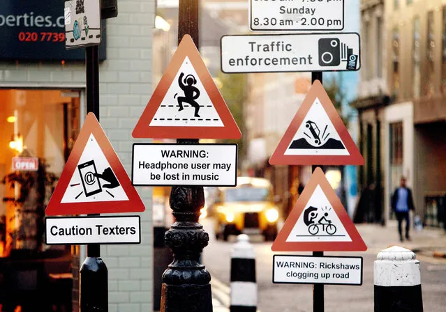 A variety of “road signs” positioned on a London street depicting the up to date hazards that Hailo taxi drivers believe should be part of the Highway Code. To celebrate Hailo, recruiting 13,500 drivers, the black cab app called upon “the knowledge” of over 500 Hailo cabbies to identify the most confusing and outdated road signs which make up the Highway Code. Hailo worked closely with their drivers to create new signs that accurately reflect 21st century driving issues. (Photo by David Parry/PA Wire)