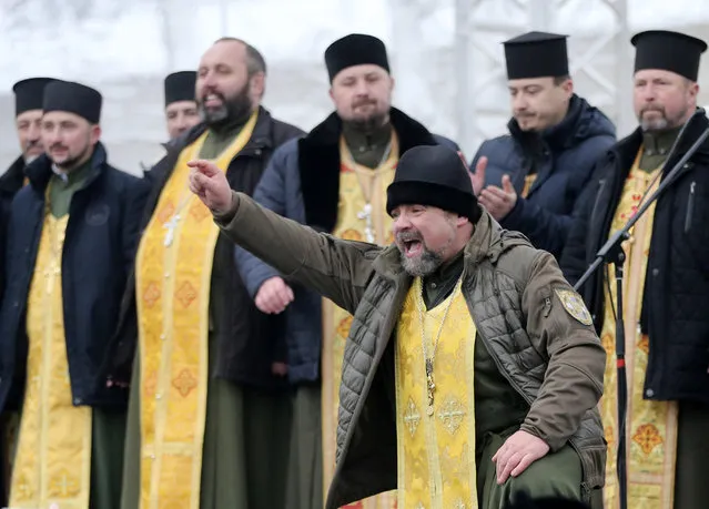 Orthodox priests bless people gathered to support independent Ukrainian church near the St. Sophia Cathedral in Kiev, Ukraine, Saturday, December 15, 2018. Ukraine's Orthodox clerics gather for a meeting Saturday that is expected to form a new, independent Ukrainian church, and Ukrainian authorities have ramped up pressure on priests to support the move. (Photo by Efrem Lukatsky/AP Photo)
