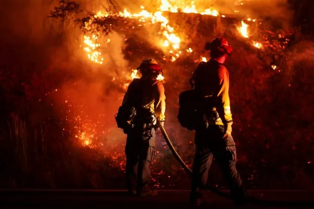 Firefighters extinguish spot fires along Route 89 Dixie Fire in Moccasin, now over 200,000 acres, California, U.S., July 28, 2021. (Photo by David Swanson/Reuters)