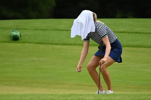 Sanna Nuutinen of Finland uses a towel to cool down on the ninth hole during round four of the women's individual stroke play at the Kasumigaseki Country Club during the 2020 Tokyo Summer Olympic Games in Kawagoe, Saitama, Japan on August 7, 2021. (Photo by Toby Melville/Reuters)