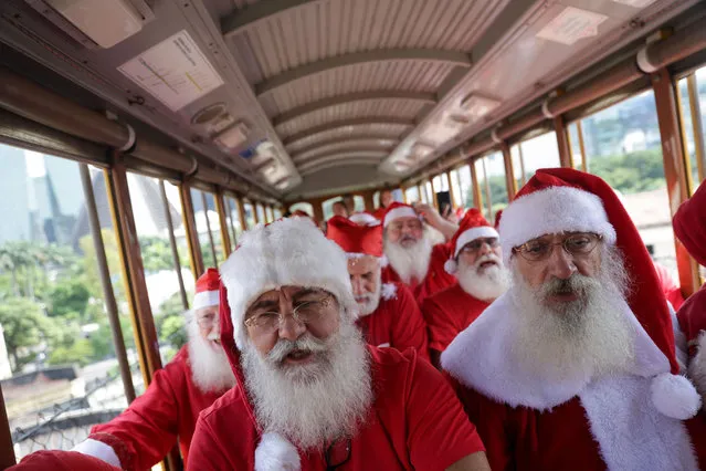Brazil's Santa Claus school members travel on a Bonde (tram) as they take part in their graduation, ahead of the Christmas season in Rio de Janeiro, Brazil on October 31, 2023. (Photo by Ricardo Moraes/Reuters)