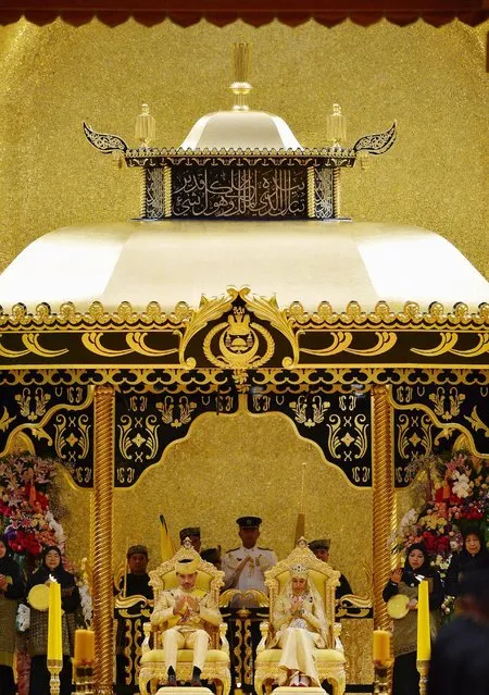 Brunei's newly wed royal couple, Prince Abdul Malik and Dayangku Raabi'atul 'Adawiyyah Pengiran Haji Bolkiah, sit during the “bersanding” or enthronement ceremony at their wedding in the Nurul Iman Palace in Bandar Seri Begawan April 12, 2015. (Photo by Olivia Harris/Reuters)