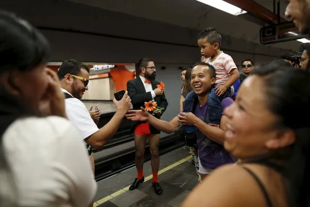 A passenger not wearing pants dance waits for a subway train as others laugh during the “No Pants Subway Ride” in Mexico City, Mexico, February 21, 2016. (Photo by Carlos Jasso/Reuters)