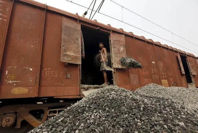 A worker unloads crushed stones from a goods wagon at a railway yard in Kolkata, India, February 25, 2016. (Photo by Rupak De Chowdhuri/Reuters)