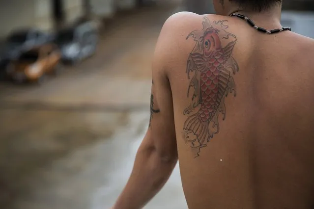 A man with a fish tattoo looks from a large fishing ship that just returned after 24 months out at sea, at a port in Mahachai, in Thailand's Samut Sakhon province April 23, 2015. (Photo by Damir Sagolj/Reuters)
