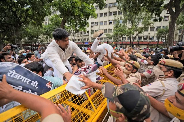 Indian Youth Congress members try to breach a police barricade during a protest held to mark Indian Prime Minister Narendra Modi's birthday in New Delhi, India, Friday, September 17, 2021. Youth members of main opposition Congress party clashed with police during a street protest Friday demanding jobs as the country’s economy recovered from the impact of the COVID-19 pandemic that triggered massive unemployment in the country. The march took place as supporters of Prime Minister Narendra Modi celebrated his birthday as he turned 71 on Friday. (Photo by Manish Swarup/AP Photo)