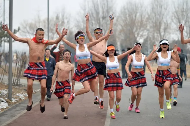 This picture taken on February 23, 2014 shows participants wearing dresses running half-naked in the annual 3.5 km Undie Run held in the Olympic Forest Park smog-covered Beijing. Some 200 participants took part in this event, many of them with gas masks,  as dangerous smog blighted swathes of northern China in recent days. (Photo by AFP Photo/STR)