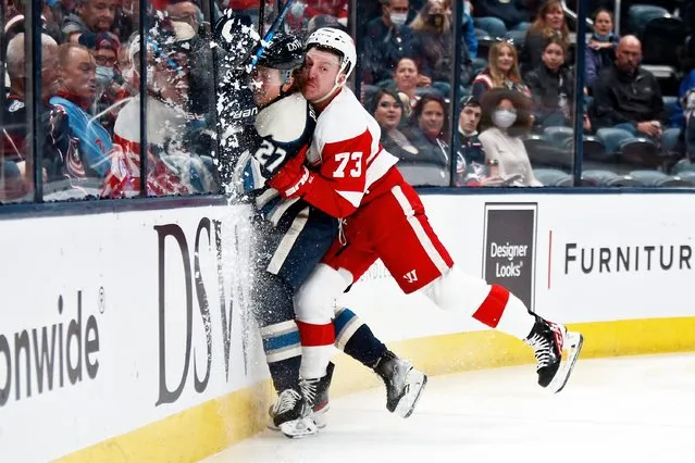 Detroit Red Wings forward Adam Erne, right, checks Columbus Blue Jackets defenseman Adam Boqvist during the first period of an NHL hockey game in Columbus, Ohio, Monday, November 15, 2021. (Photo by Paul Vernon/AP Photo)