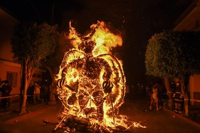 A figure representing the devil burns during the celebration of the Virgin of the Immaculate Conception, in Guatemala City, on December 7, 2021. The event marks the beginning of the Chritmas season in Guatemala. (Photo by Orlando Estrada/AFP Photo)