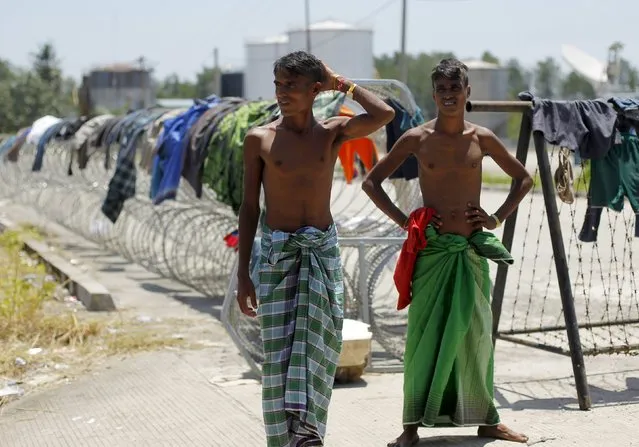 Bangladeshi migrants, who recently arrived in Indonesia by boat, stand near a barbed wire at a shelter in Kuala Langsa, in Indonesia's Aceh Province, May 19, 2015. (Photo by Reuters/Beawiharta)