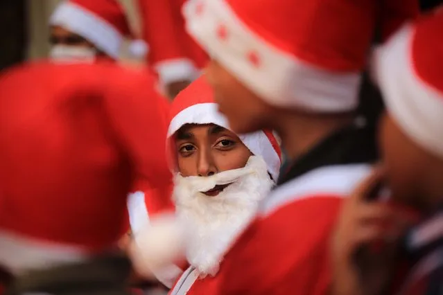 Members of Pakistan's Christian minority dressed as Santa Clauses take part in a pre-Christmas rally on a street in Peshawar, Pakistan, 20 December 2021.  Pakistan is a Sunni-majority Muslim country with four million Christians out of a total population of about 200 million. (Photo by Bilawal Arbab/EPA/EFE)