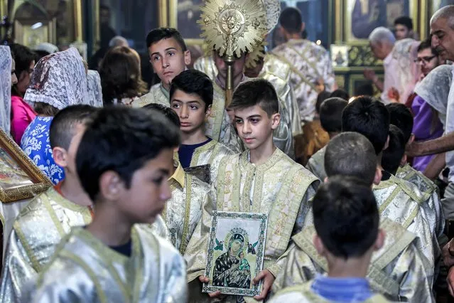 Child deacons walk in a procession during the Palm Sunday service, marking the start of Holy Week for Orthodox Christians, at the Greek Orthodox Church of St Porphyrius (Porphyrios) in Gaza City on April 28, 2024, amid the ongoing conflict in the Gaza Strip between Israel and the militant group Hamas. (Photo by AFP Photo/Stringer)