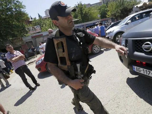 An armed policeman walks after police killed a white tiger that had escaped from its enclosure during flooding, in Tbilisi, Georgia, June 17, 2015. Tigers, lions, bears and wolves were among more than 30 animals that escaped from a Georgian zoo and onto the streets of the capital Tbilisi on Sunday during floods that killed at least 12 people. REUTERS/David Mdzinarishvili