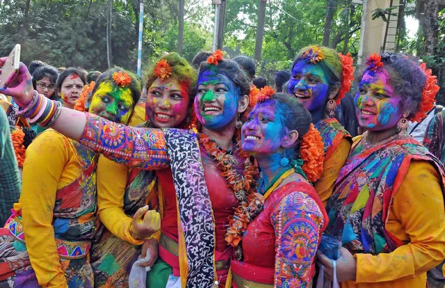 Students in traditional attire take selfie as they play holi during “Basant Utsav”, in Kolkata, India on Sunday, March 12, 2017. (Photo by PTI Photo)