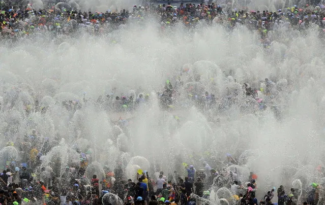 Visitors participate in the annual water-splashing festival to mark the New Year of the Dai minority in Xishuangbanna, Yunnan province April 15, 2014. Last Sunday marked the beginning of the 1,376th New Year, according to the ethnic Dai minority calendar. (Photo by Reuters/China Daily)