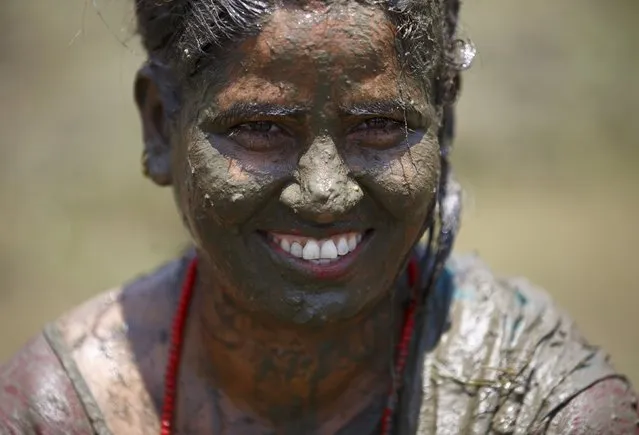 A woman covered in mud smiles during the Asar Pandhra festival in Pokhara valley, west of Nepal's capital Kathmandu, June 30, 2015. (Photo by Navesh Chitrakar/Reuters)