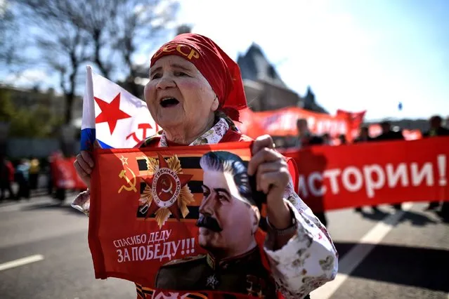 A Russian Communist party activist carries a banner with an image of late Soviet leader Joseph Stalin during a May Day rally in central Moscow on May 1, 2016. (Photo by Kirill Kudryavtsev/AFP Photo)