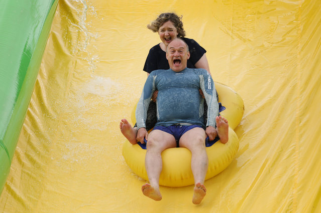 Ed Davey, leader of the Liberal Democrats, and Anna Sabine, parliamentary candidate for Frome and East Somerset, ride the Ultimate Slip 'n' Slide at Eastcote Farm during an election campaign visit in Beckington, UK, on Thursday, May 30, 2024. The Conservatives face a fight in their traditional Blue Wall heartland from the centrist Liberal Democrats. (Photo by Hollie Adams/Bloomberg via Getty Images)