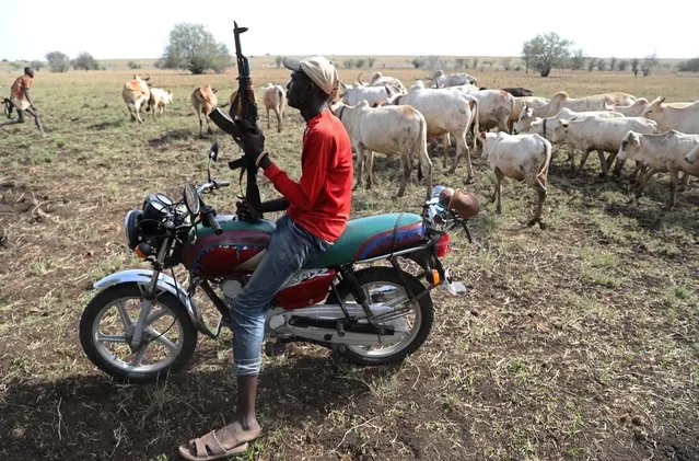 A Turkana warrior holds a gun as he protects cattle from Nyangatom warriors in Ilemi Triangle, Kenya, July 22, 2019. (Photo by Goran Tomasevic/Reuters)