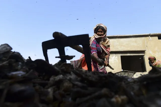 A woman sorts waste at a local factory in Karachi on March 7, 2022. (Photo by Asif Hassan/AFP Photo)
