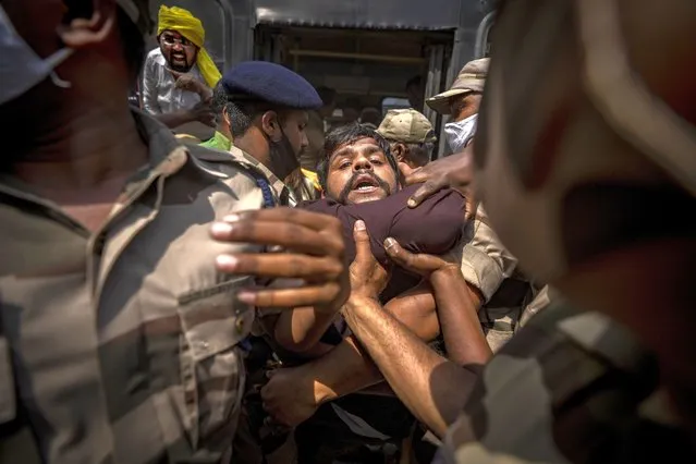Indian paramilitary soldiers detain an opposition Congress party supporter during a protest against rising inflation and price hike of essential commodities in New Delhi, India, Wednesday, March 23, 2022. (Photo by Altaf Qadri/AP Photo)