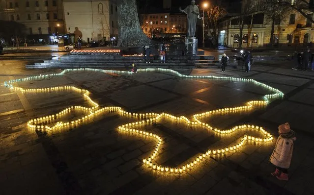 Ukrainians light candles in form of Ukrainian map on the central square of Western Ukrainian city of Lviv, 05 April 2022. Hundreds of candles were lit  in memory of the innocent civilian Ukrainians killed in the Russian invasion. On 24 February, Russian troops had entered Ukrainian territory in what the Russian president declared a “special military operation”, resulting in fighting and destruction in the country, a huge flow of refugees, and multiple sanctions against Russia. (Photo by Mykola Tys/EPA/EFE)