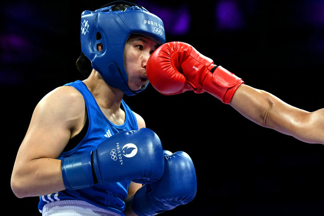 Vietnam's Ha Thi Linh takes a punch from Tonga's Feofaaki Epenisa in the women's 60kg preliminaries round of 32 boxing match during the Paris 2024 Olympic Games at the North Paris Arena, in Villepinte on July 27, 2024. (Photo by Mohd Rasfan/AFP Photo)