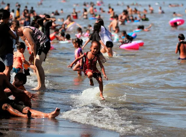 Filipinos go for a swim and frolic in the polluted waters of Manila Bay on Maundy Thursday in Noveleta, Cavite province, Philippines, 14 April 2022. Filipinos take the time for vacation during the Lenten season as COVID-19 travel restrictions continue to be lifted nationwide. (Photo by Francis R. Malasig/EPA/EFE)