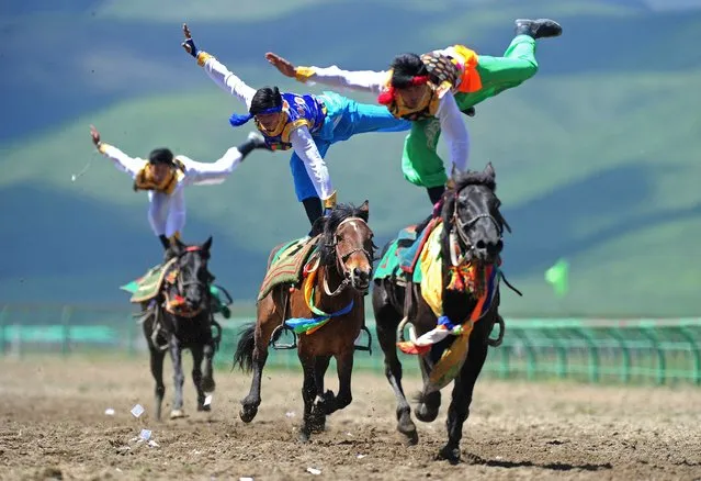 This picture taken on June 17, 2014 shows riders wearing ethnic group costume competing in a traditional horseback riding event in Hongyuan county of Aba town, or Ngawa town, southwest China's Sichuan province. Some 300 riders from 15 teams around the country took part in the traditional horseback riding event, local media reported. (Photo by AFP Photo)