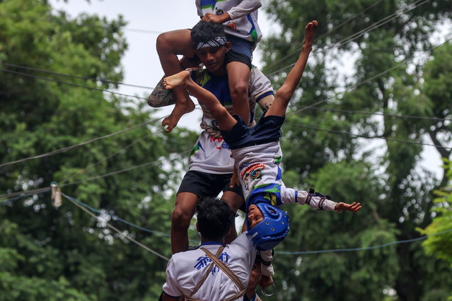 Indian devotees fall while forming a human pyramid to reach and break a “dahi-handi” (curd-pot), on the occasion of the Janmashtami Festival in Mumbai, India, 27 August 2024. Hindu devotees take part in the celebration, in which an earthen pot is suspended high above the ground and young men and children form a human pyramid to reach the pot and break it. The festival celebrates the birth of the Hindu god Lord Krishna, one of the most popular gods in Hinduism. (Photo by Divyakant Solanki/EPA)