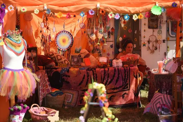 A woman waits to receive customers on her stall at the Glastonbury Festival of Music and Performing Arts on Worthy Farm near the village of Pilton in Somerset, South West England, on June 21, 2017. (Photo by Oli Scarff/AFP Photo)