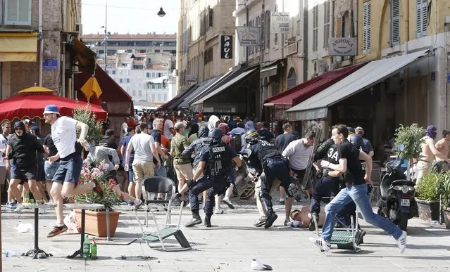 French police officers charge soccer supporters during clashes in downtown Marseille, France, Saturday, June 11, 2016. (Photo by Darko Bandic/AP Photo)