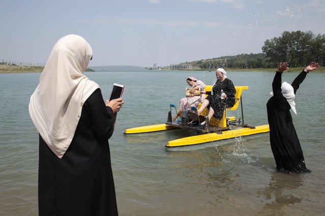 Chechen women enjoy themselves in the water on the outskirts of the regional Chechen capital of Grozny, Russia, Tuesday, August 3, 2015. (Photo by Musa Sadulayev/AP Photo)