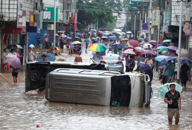 Automobiles are seen overturned on a flooded street in Liuzhou, Guangxi Zhuang Autonomous Region, China, June 14, 2016. (Photo by Reuters/Stringer)