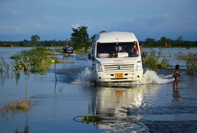People travel in a mini bus at flood-hit Jamlai village in Kamrup district of Assam on Thursday, July 14, 2017. (Photo by Press Trust of India Photo)