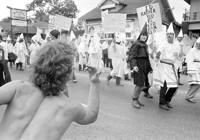A spectator gestures to the Ku Klux Klan marchers as the KKK paraded through the heart of Houston's gay community  Saturday, June 9, 1984. About 55 members of the Klan marched under the protection of hundreds of policemen. There was a lot of shouting between the opponents, but no clashes. (Photo by AP Photo/RC)