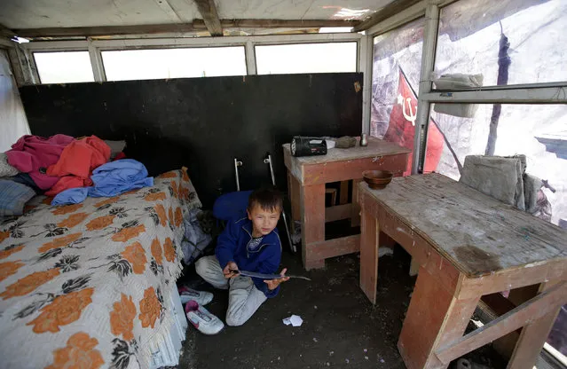 A 7-year-old boy plays in villager Munkhtsetseg's shack at a village on the outskirts of Ulan Bator, Mongolia, June 27, 2016. (Photo by Jason Lee/Reuters)