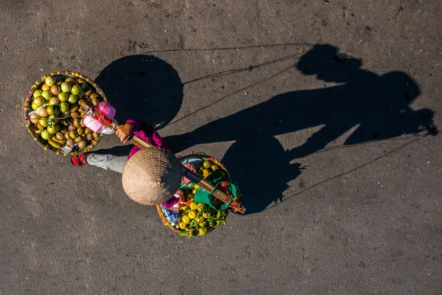 The photographer said each streetseller spent lots of time perfecting the arrangement of their goods in Vietnam, Hanoi, December 2016. Simplistic aerial views reveal the subtle beauty of Hanoi’s mobile street sellers. Photographer Claudio Sieber spent many hours on bridges across Hanoi, Vietnam to find the perfect spot to capture the vibrant colours and wares of local street sellers. Some of the streetsellers use their bikes as a mobile kitchen, preparing fresh meals on the spot, while others offer coffee, vegetables and flowers. (Photo by Claudio Sieber/Barcroft Images)