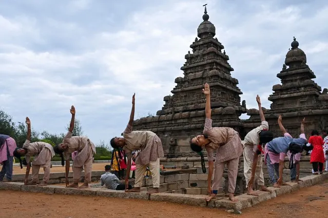 Students participate in a yoga session to celebrate the International Day of Yoga at the Shore Temple in Mahabalipuram on June 21, 2022. (Photo by Arun Sankar/AFP Photo)