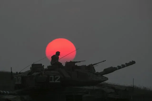 An Israeli tank manoeuvres outside the northern Gaza Strip July 21, 2014. The Palestinian death toll in an Israeli offensive in the Gaza Strip jumped to more than 500 on Monday, as the United States, alarmed by escalating civilian bloodshed, took a direct role in efforts to secure a ceasefire. Israel's losses also mounted. Following the death of 13 soldiers on Sunday, Israel said seven more troops had died on Monday, including four killed when a group of militants tunnelled across the border from Gaza and fired at their jeep. (Photo by Baz Ratner/Reuters)