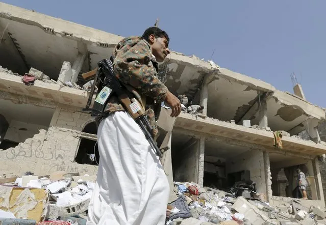 A Houthi militant walks past the offices of the education ministry's workers union, destroyed by Saudi-led air strikes, in Yemen's northwestern city of Amran August 19, 2015. (Photo by Khaled Abdullah/Reuters)