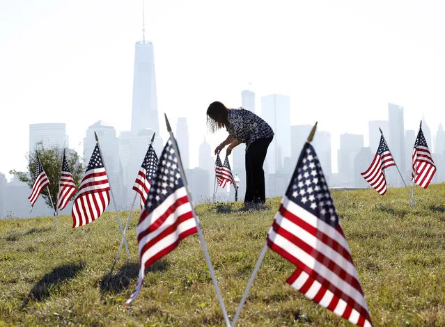 Yalenny Vargas arranges flags for the Fourth Of July celebrations at Liberty State Park on Monday, July 4, 2016, in Jersey City, N.J. (Photo by Mel Evans/AP Photo)